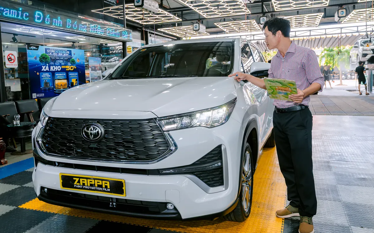 Kỹ thuật viên Store Detailing soi đèn kiểm tra tình trạng sơn xe trước khi dán PPF